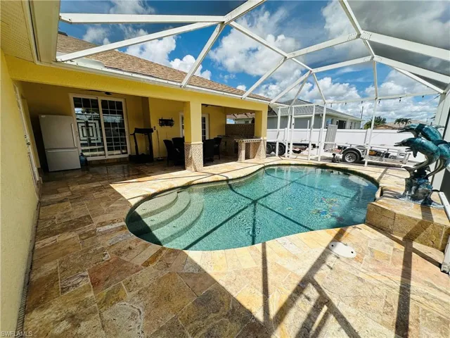 View of swimming pool with a patio and glass enclosure