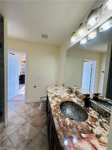 Bathroom with tile patterned flooring, vanity, and toilet