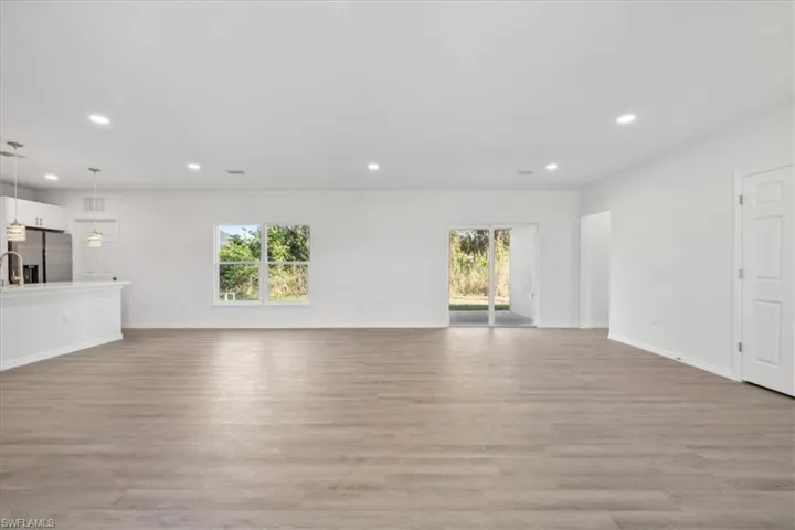 Unfurnished living room featuring light hardwood / wood-style floors and a healthy amount of sunlight