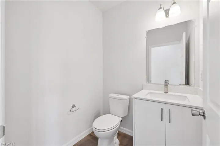 Bathroom with hardwood / wood-style floors, vanity, and toilet