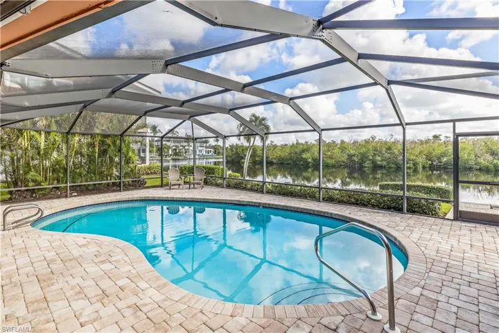 View of swimming pool with a patio area, a water view, and a lanai