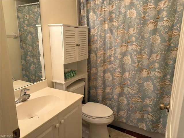 Bathroom with vanity, tile patterned flooring, and a shower with shower curtain