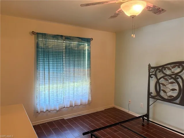 Unfurnished bedroom featuring dark wood-style floors and ceiling fan