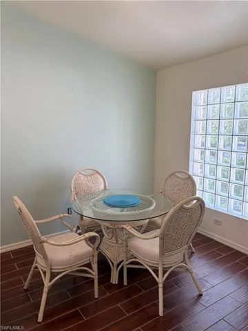 Dining room featuring dark wood-type flooring and baseboards
