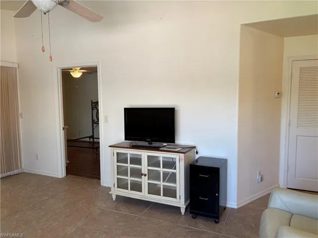Tiled living room featuring ceiling fan