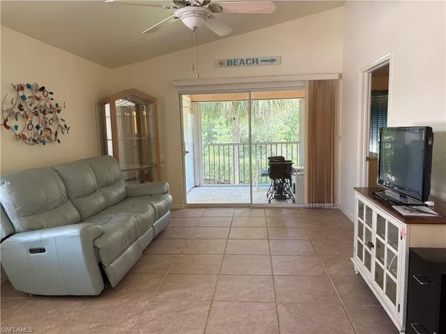 Living area featuring lofted ceiling, ceiling fan, and tile patterned flooring