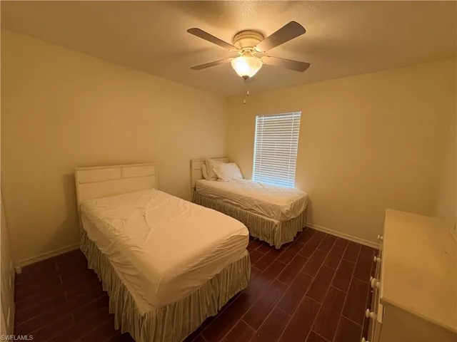 Bedroom featuring dark wood-style flooring and a ceiling fan