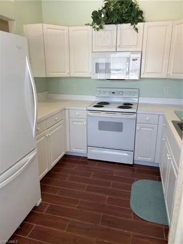 Kitchen featuring refrigerator, white electric range, wood finish floors, and white cabinets