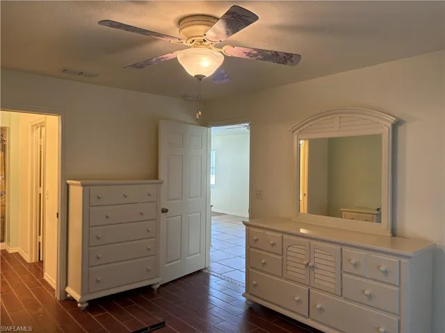 Unfurnished bedroom featuring dark wood-style flooring and a ceiling fan