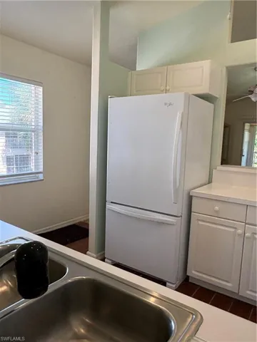 Kitchen featuring freestanding refrigerator, white cabinetry, light countertops, dark wood-style floors, and ceiling fan