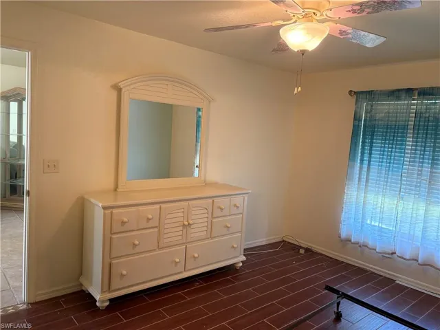 Unfurnished bedroom featuring wood tiled floors, multiple windows, and ceiling fan
