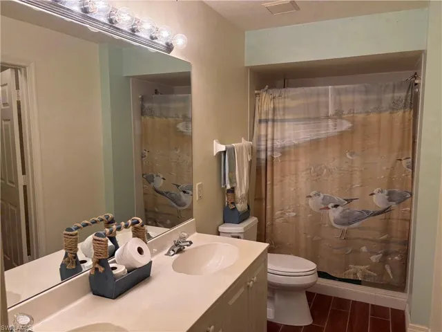 Full bath with double vanity, wood finished floors, and a shower with curtain