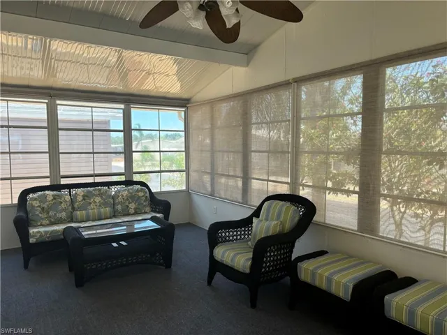 Sunroom / solarium with ceiling fan and lofted ceiling with beams