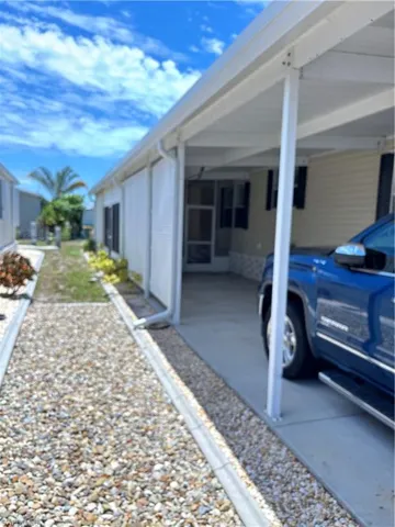 View of parking / parking lot featuring a carport