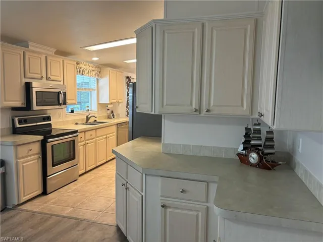 Kitchen featuring sink, light hardwood / wood-style floors, and appliances with stainless steel finishes