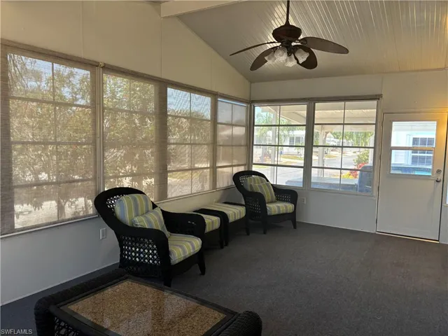 Sunroom with ceiling fan and vaulted ceiling with beams