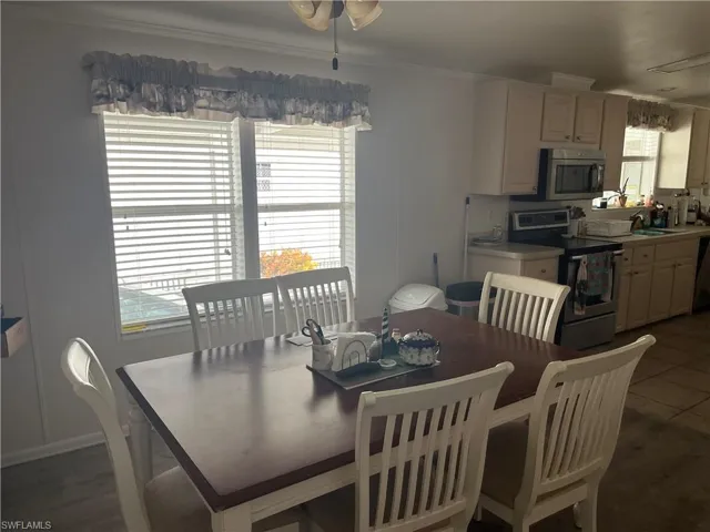 Dining room featuring ornamental molding, a healthy amount of sunlight, and dark tile floors