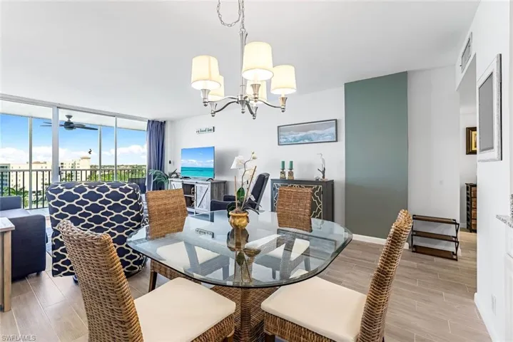 Dining room with expansive windows, light hardwood / wood-style flooring.
