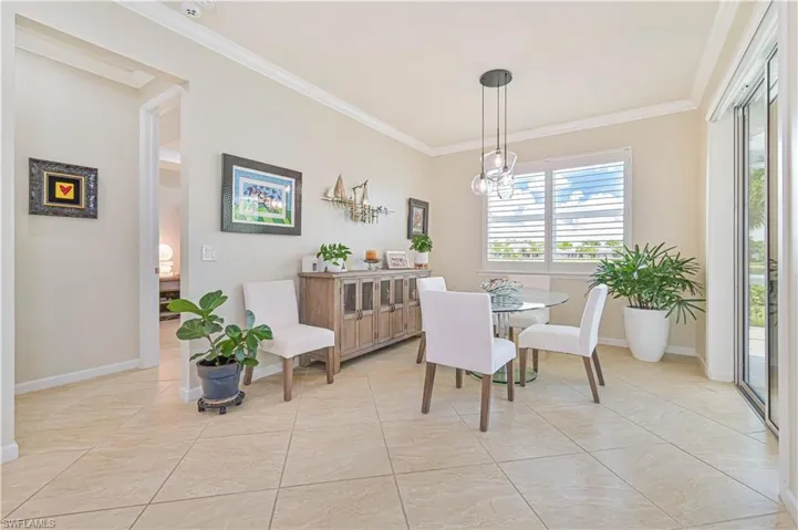 Dining space with ornamental molding, healthy amount of natural light, and light tile patterned flooring