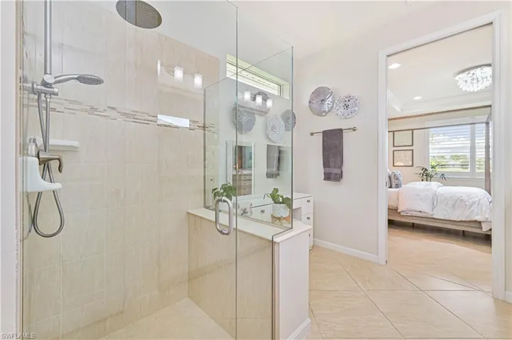 Ensuite bathroom featuring a shower stall and baseboards