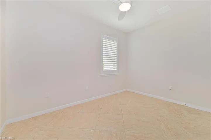 Empty room with baseboards and a ceiling fan
