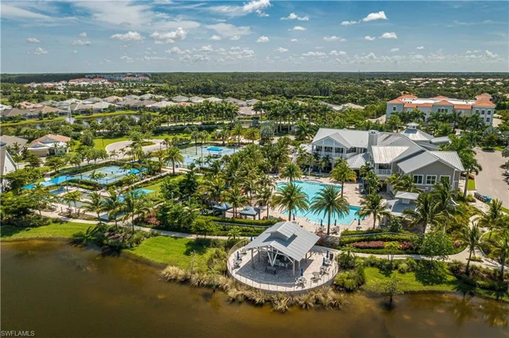 Drone / aerial view of a pool area and a nearby body of water