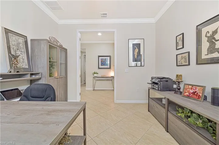 Home office featuring crown molding and light tile patterned flooring