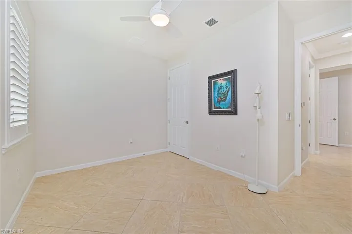 Unfurnished room with a ceiling fan and baseboards