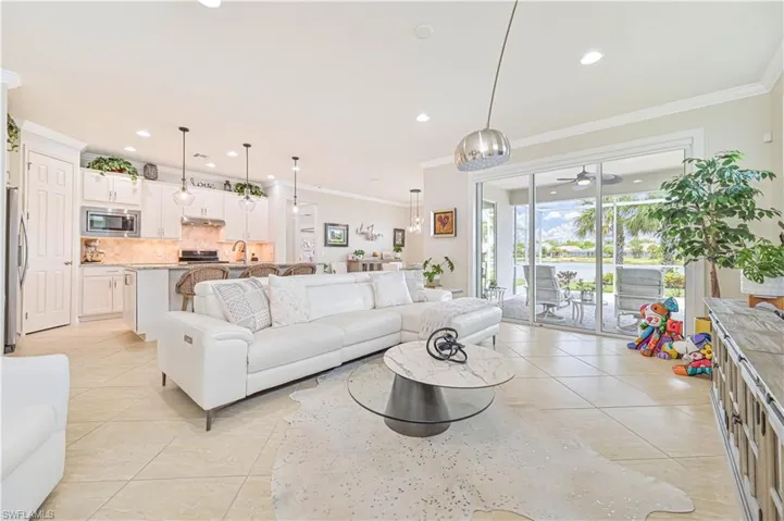 Living room with light tile patterned flooring, ornamental molding, a ceiling fan, and recessed lighting