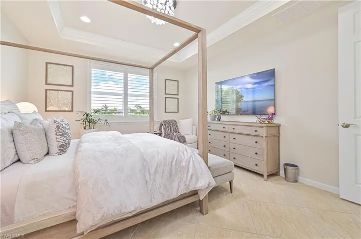 Bedroom featuring ornamental molding, a tray ceiling, and recessed lighting