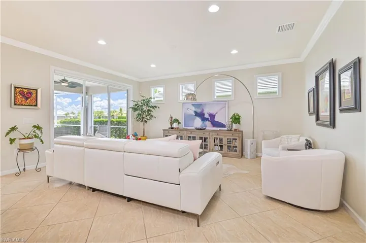 Living area with light tile patterned flooring, crown molding, plenty of natural light, and recessed lighting