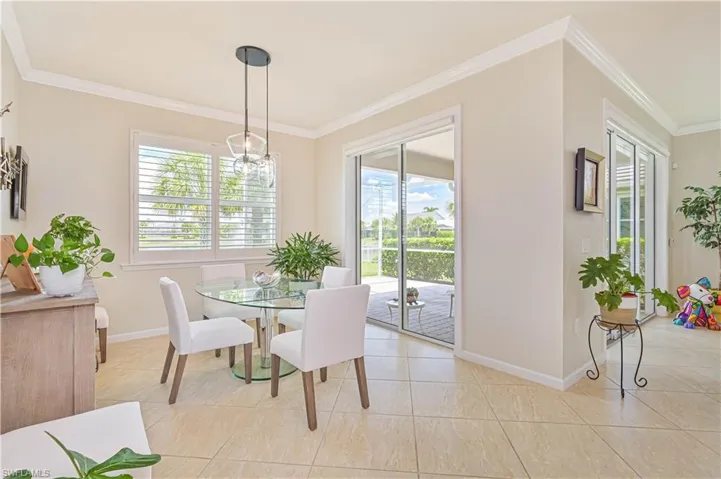 Dining space with ornamental molding and light tile patterned flooring