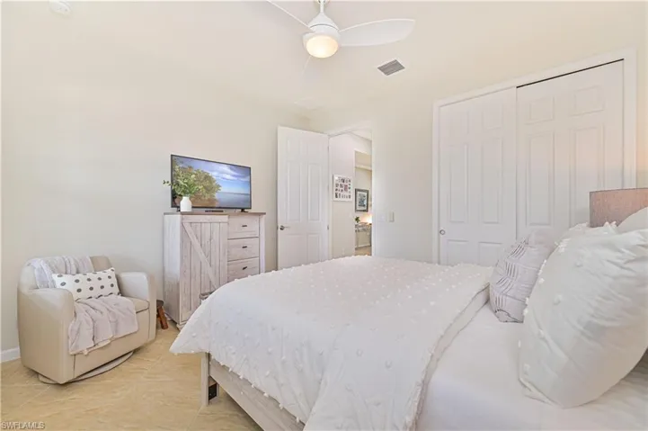 Bedroom with ceiling fan, a closet, and light tile patterned floors