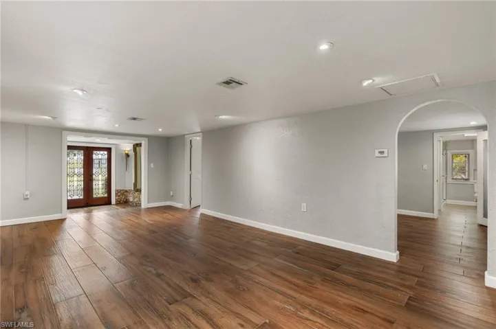 Unfurnished room with french doors, dark hardwood / wood-style floors, and a wealth of natural light