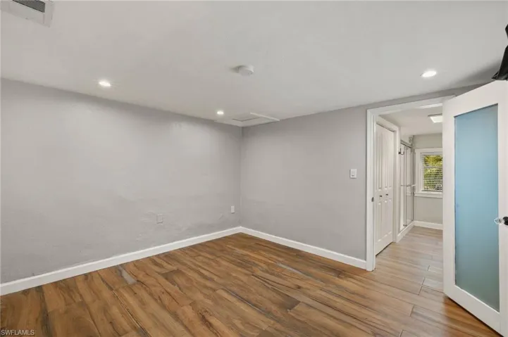Empty room with hardwood / wood-style flooring