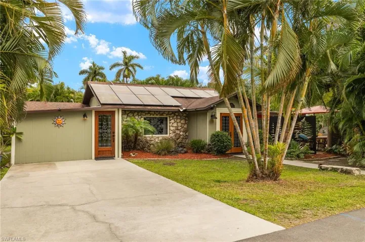 View of front of home featuring a front yard and solar panels