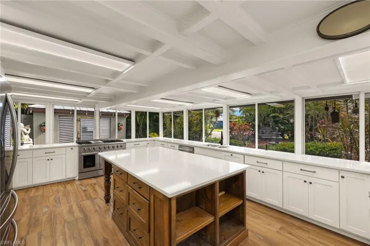 Kitchen featuring kitchen peninsula, appliances with stainless steel finishes, light hardwood / wood-style floors, and white cabinetry