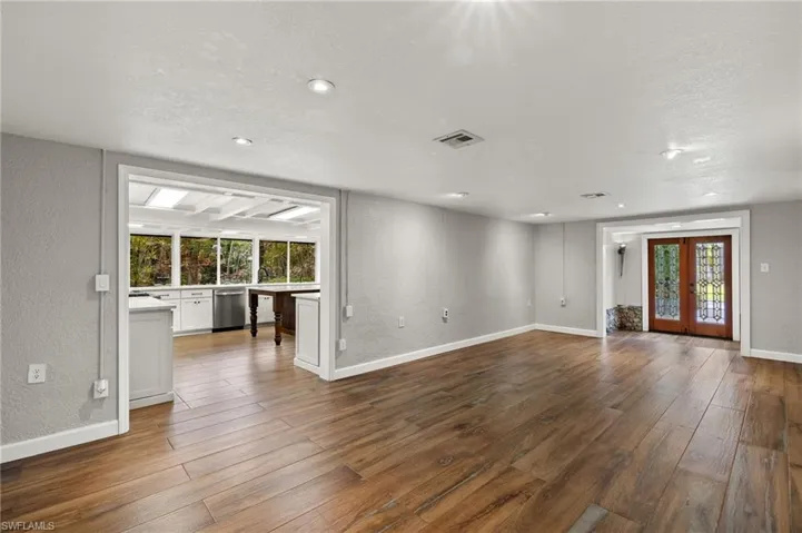 Unfurnished living room with hardwood / wood-style flooring, a textured ceiling, and french doors