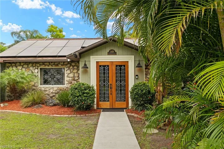 View of exterior entry with french doors and solar panels