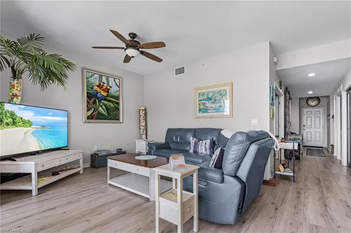 Living room with light vinyl flooring and ceiling fan