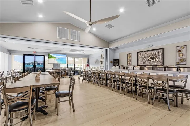 Dining area with light vinyl flooring, vaulted ceiling, ceiling fan, and recessed lighting