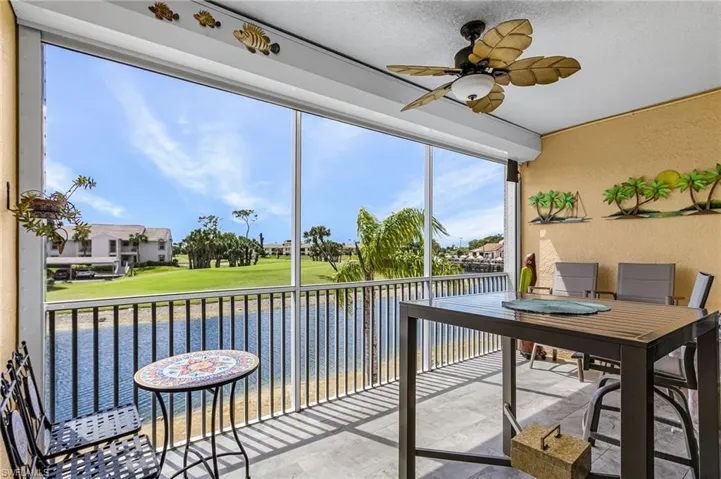 Sunroom featuring ceiling fan and a balcony