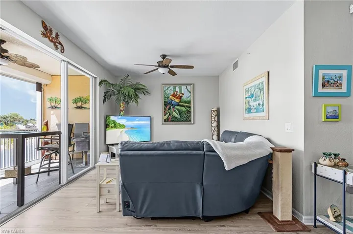 Living room featuring a ceiling fan and light vinyl flooring