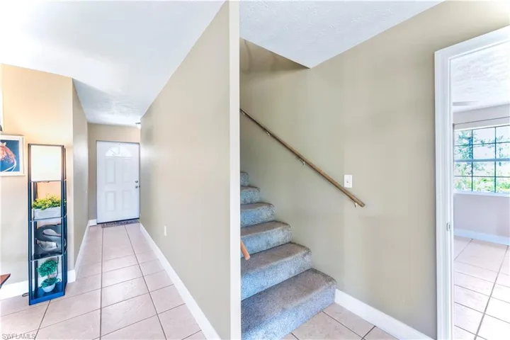Stairs featuring light tile floors