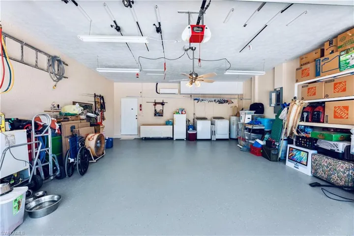 Garage with a garage door opener and ceiling fan