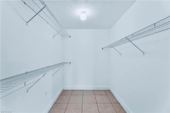 Walk in closet featuring light tile floors