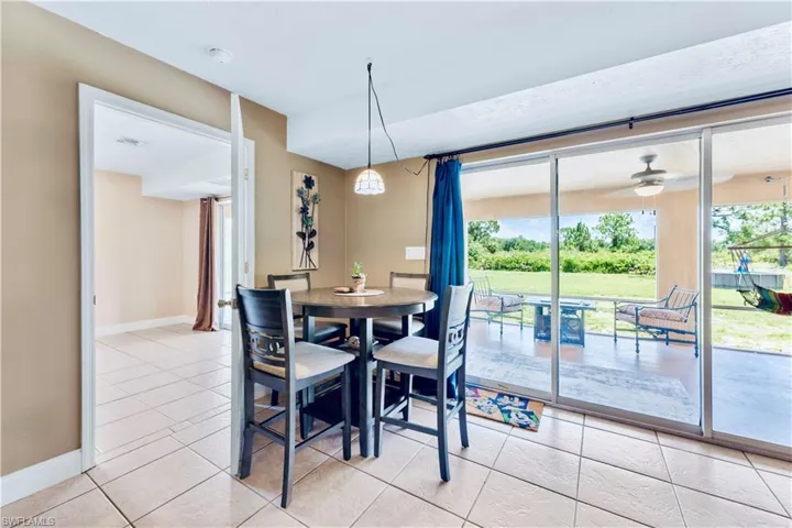 Tiled dining space with plenty of natural light and ceiling fan
