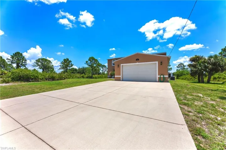 View of front of property with a front yard and a garage