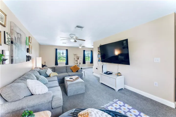 Living room featuring carpet and ceiling fan