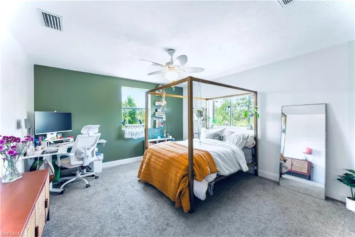Carpeted bedroom featuring ceiling fan